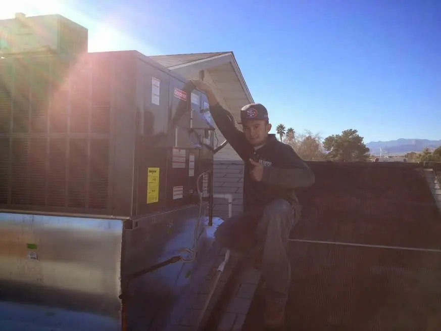 HVAC technician performing HVAC Inspection on a rooftop unit in Sandy Springs